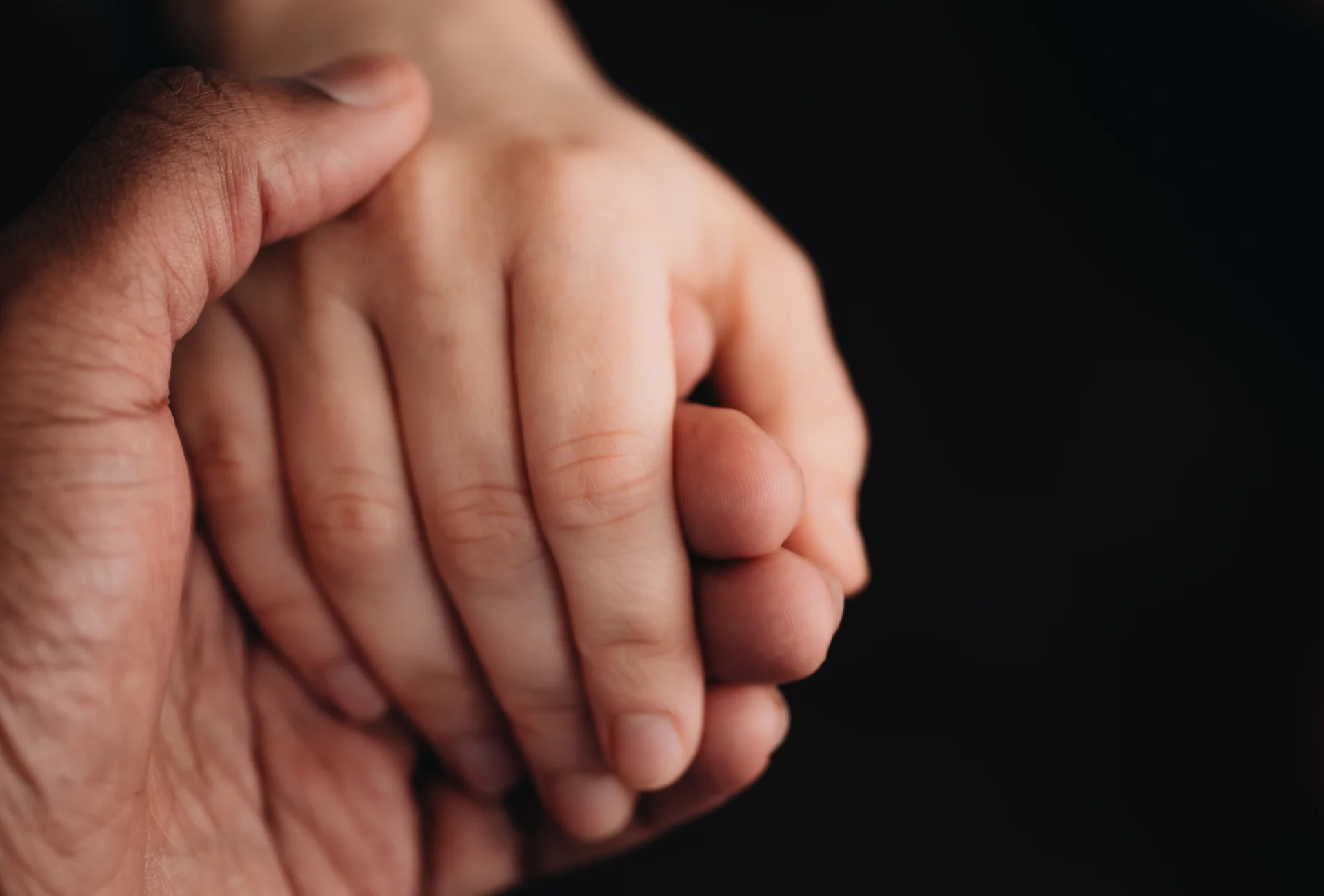 Hands holding each other, symbolizing support and connection in the context of alcohol addiction treatment and recovery.