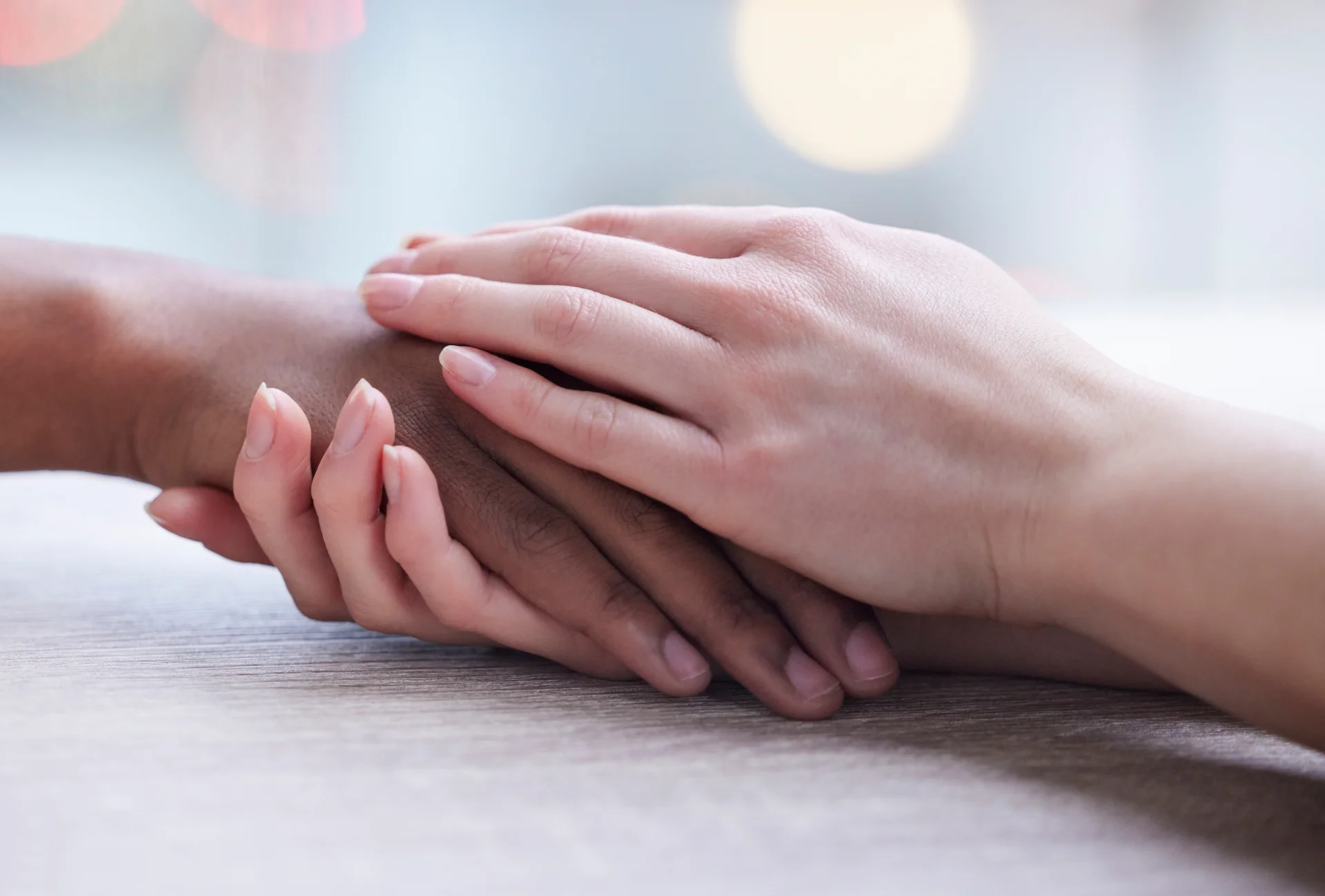 Hands of diverse individuals gently resting together, symbolizing support and connection in the context of addiction recovery at Hudson Valley Addiction Treatment Center.