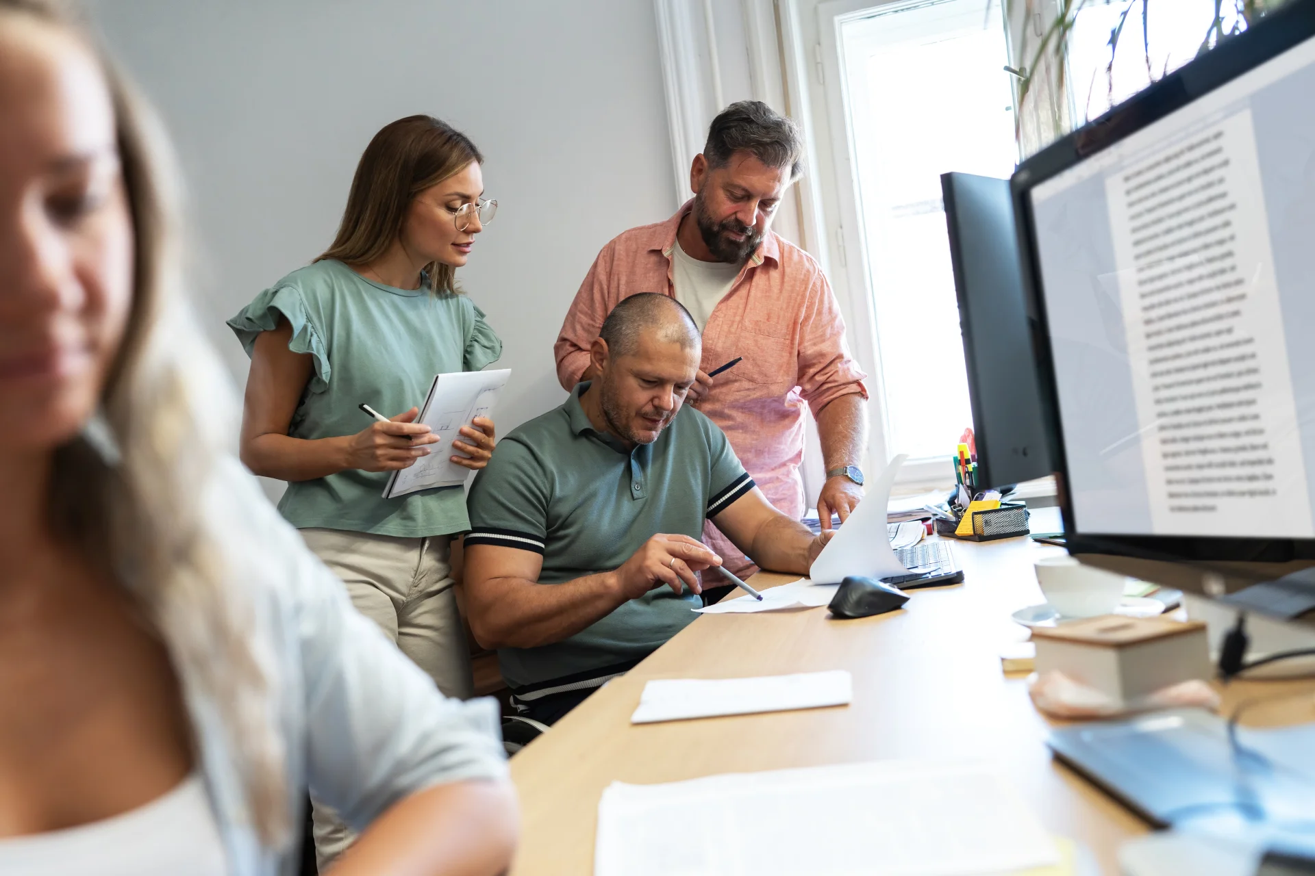 Team collaborating in a modern office, discussing documents and strategies for addiction and mental health treatment at Hudson Valley Addiction Treatment Center.